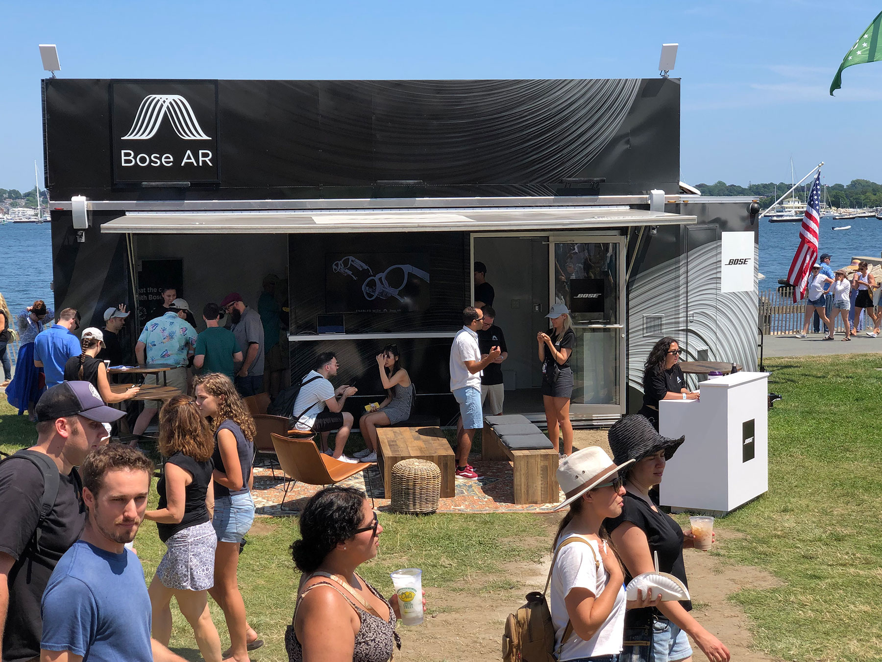 exterior view of Bose retail booth with people walking by and chatting