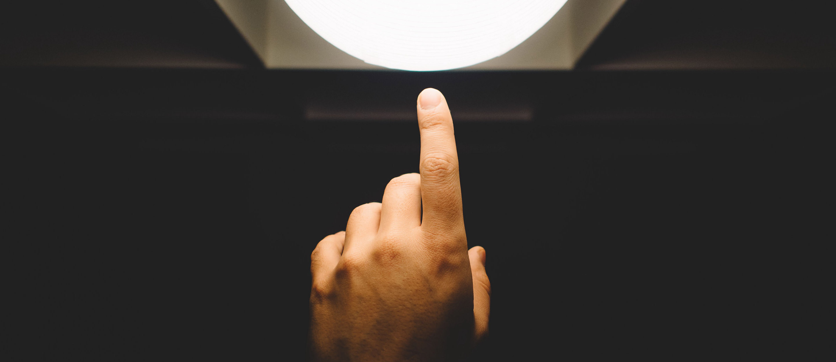 Finger touching a lightblub